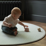 Little boy enjoys stacking cups on large round baby playmat with plenty of space to play