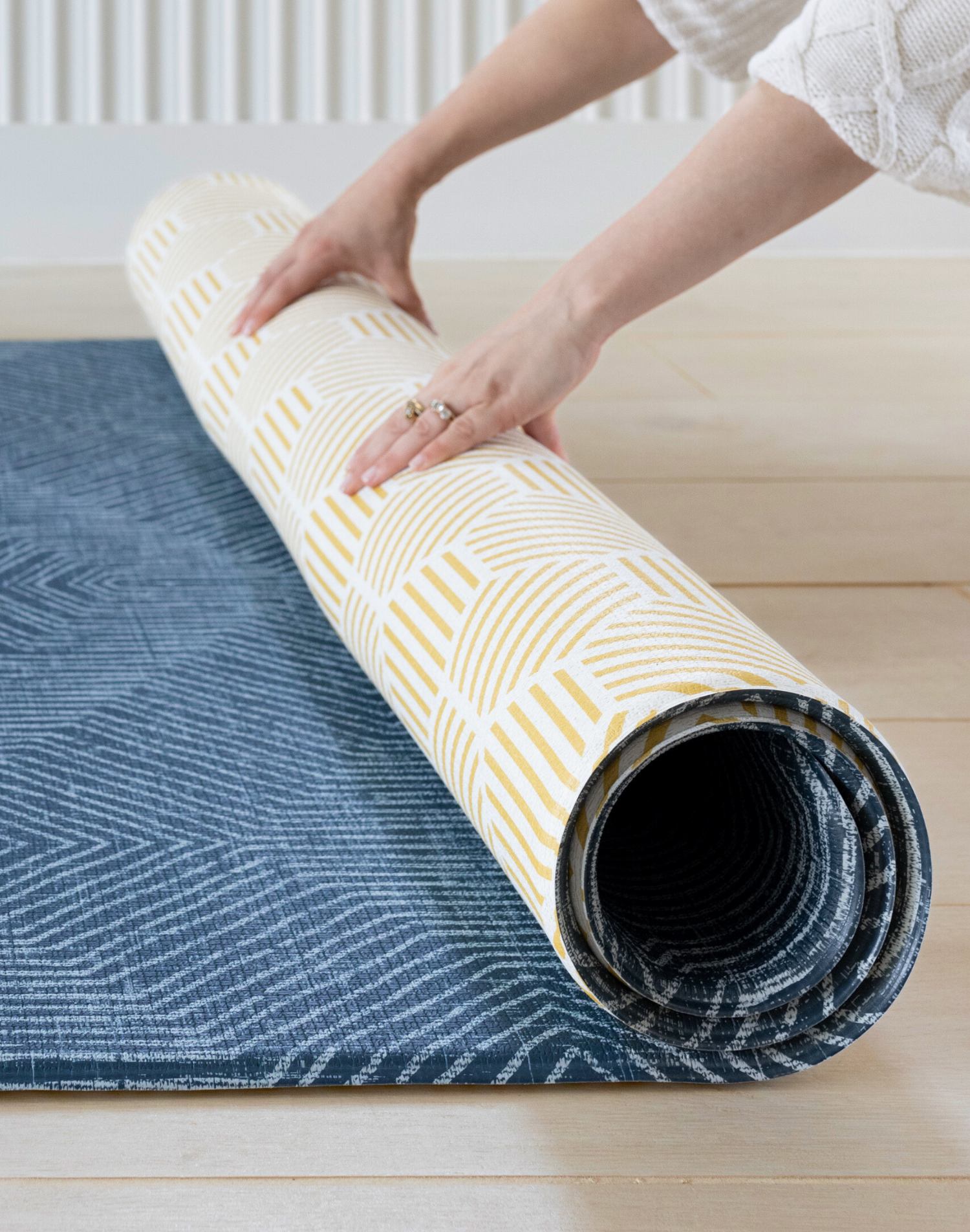 Unrolling thick one piece play rug by Totter and Tumble with Wanderlust design and honeycomb Keeper on the reverse