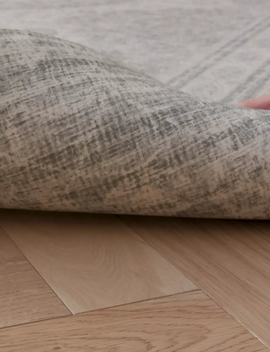 A video of a hand lifting up a rug-like extra large playmat. On the reverse we see a stylish grey patterned deign