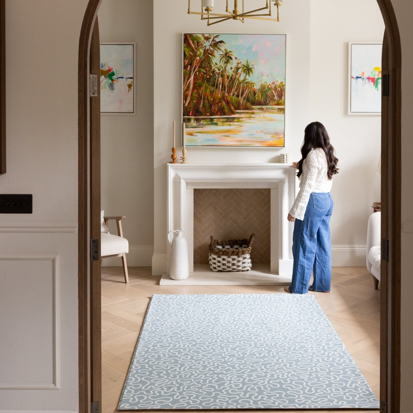 A sophisticated living room interior featuring a large soft blue rug-like playmat