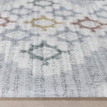 Close-up of a thick totter and tumble play mat with geometric designs on a neutral blue background