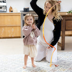 Pregnant mum playing with toddler on the floor knees on her totter and tumble playmat. 