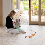 pregnant mother and child sitting on the totter and tumble playmat 