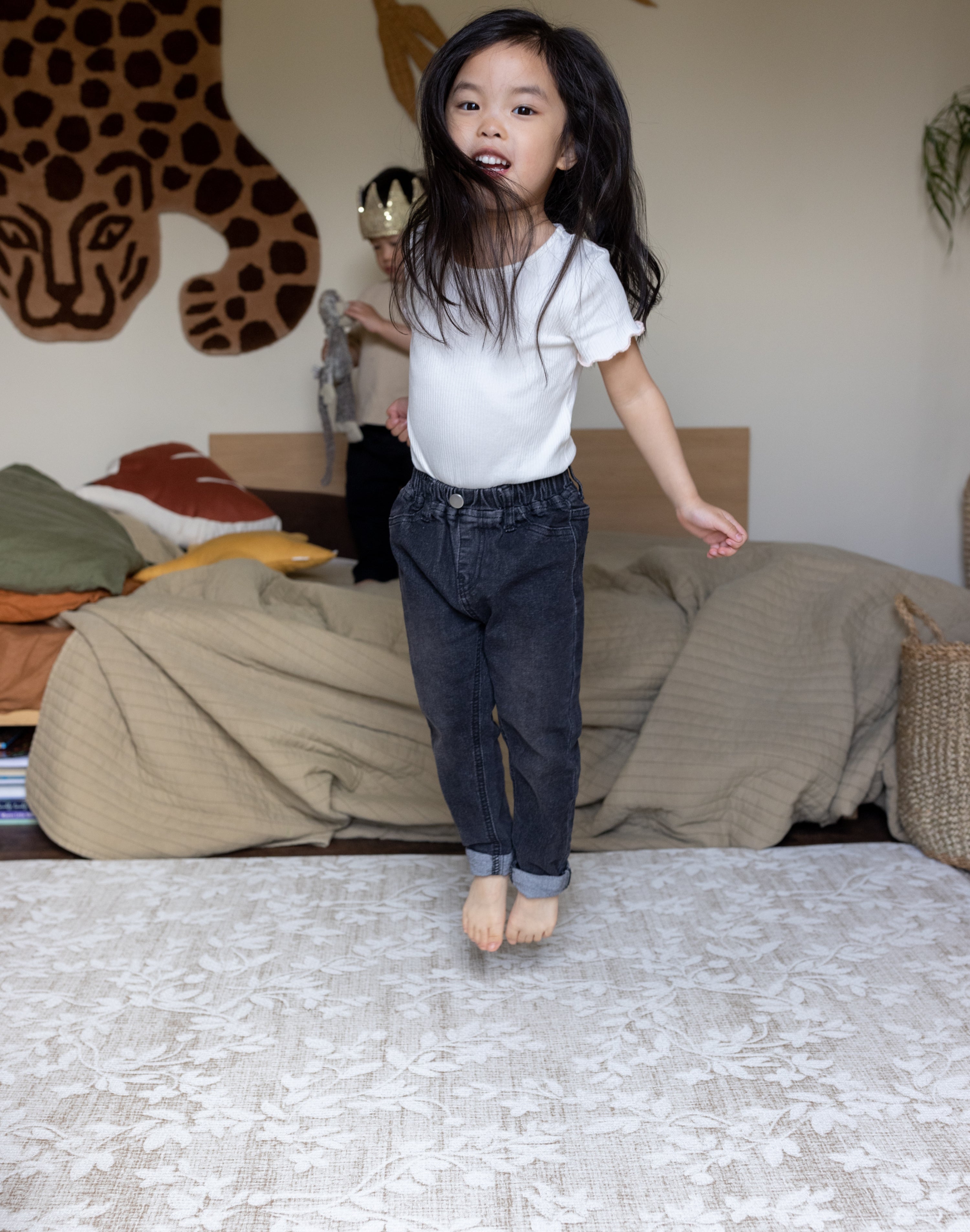 Child jumping on bedroom floor with cushioning padded playmat to soften her jumps! 
