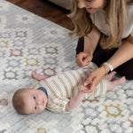 Woman playing with a  newborn baby on a Totter + Tumble playmat perfect maternity or welcome to the world gift baby shower