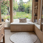 Round shape playmat in the corner of a kitchen library space - it looks like a rug, subtle designs for every family home.