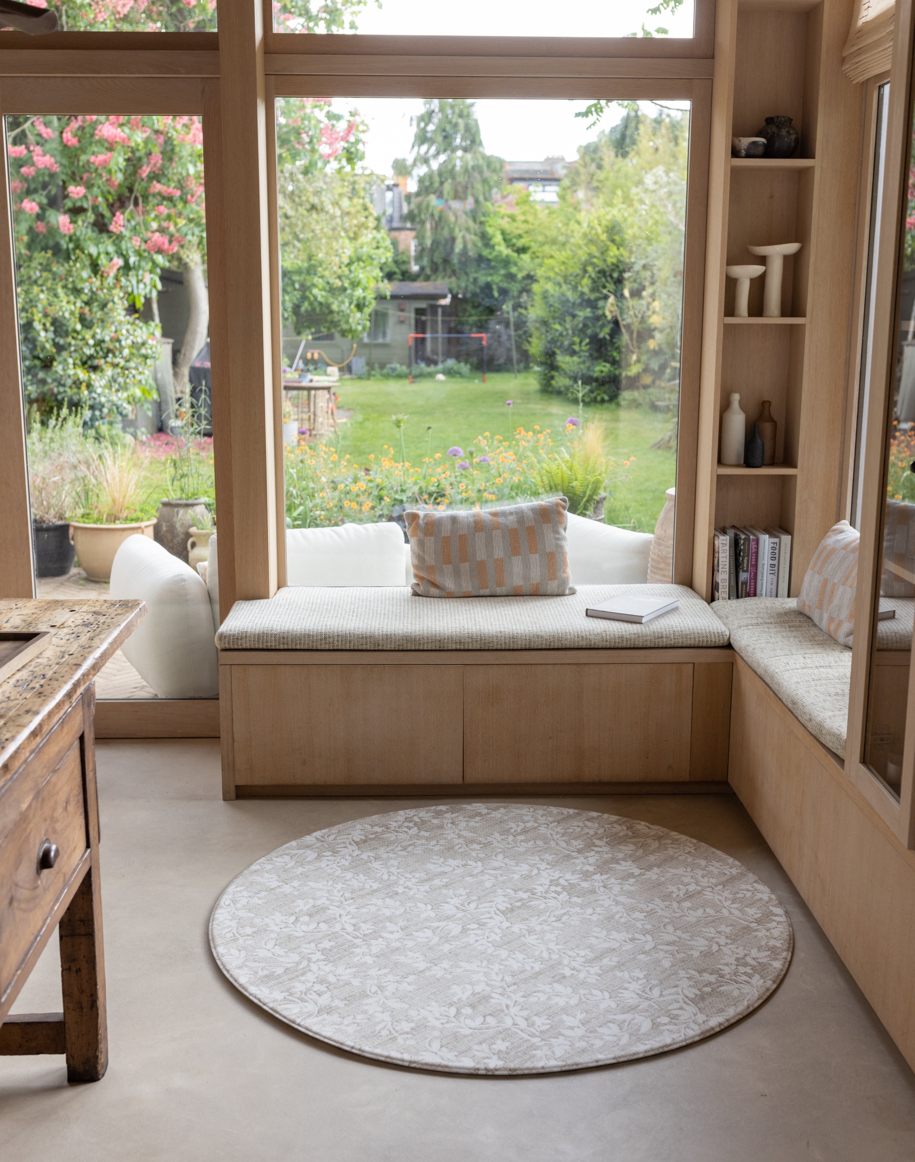 Round shape playmat in the corner of a kitchen library space - it looks like a rug, subtle designs for every family home.