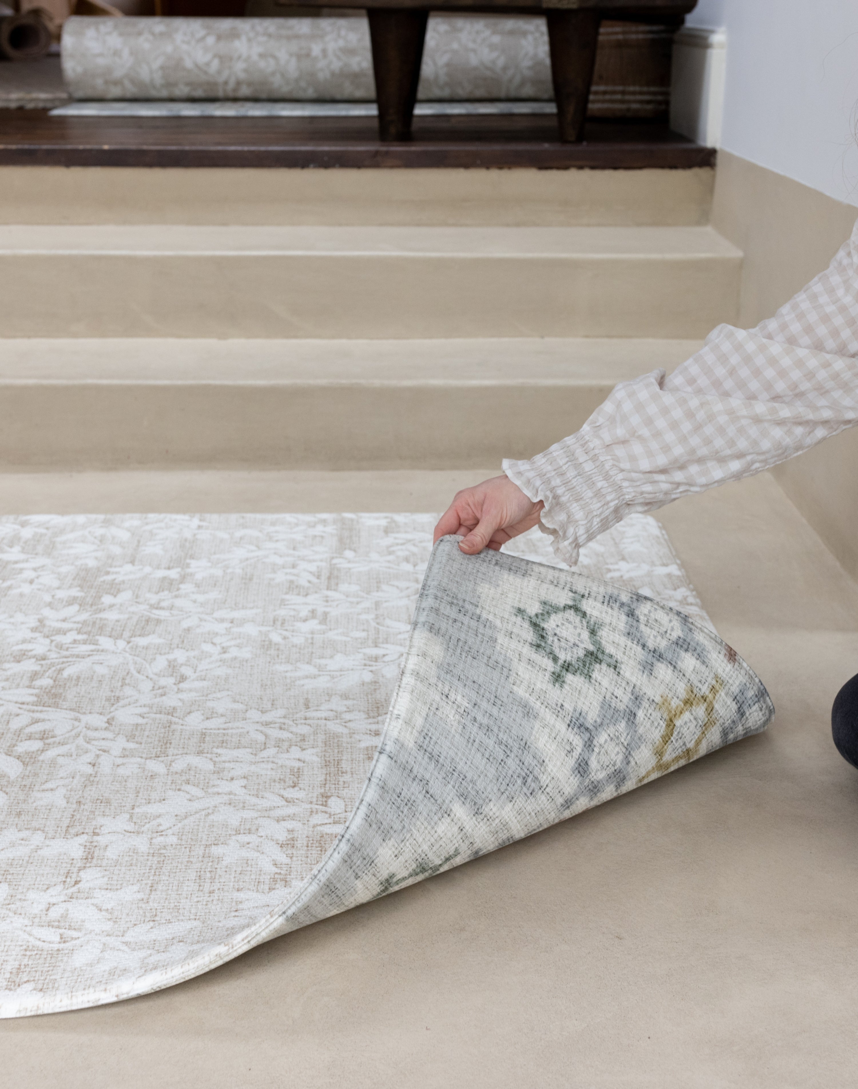 reverisble play mat being held by the corner to show both designs. 