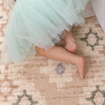 little girl crawling on baby playmat in pretty pink design The Fable