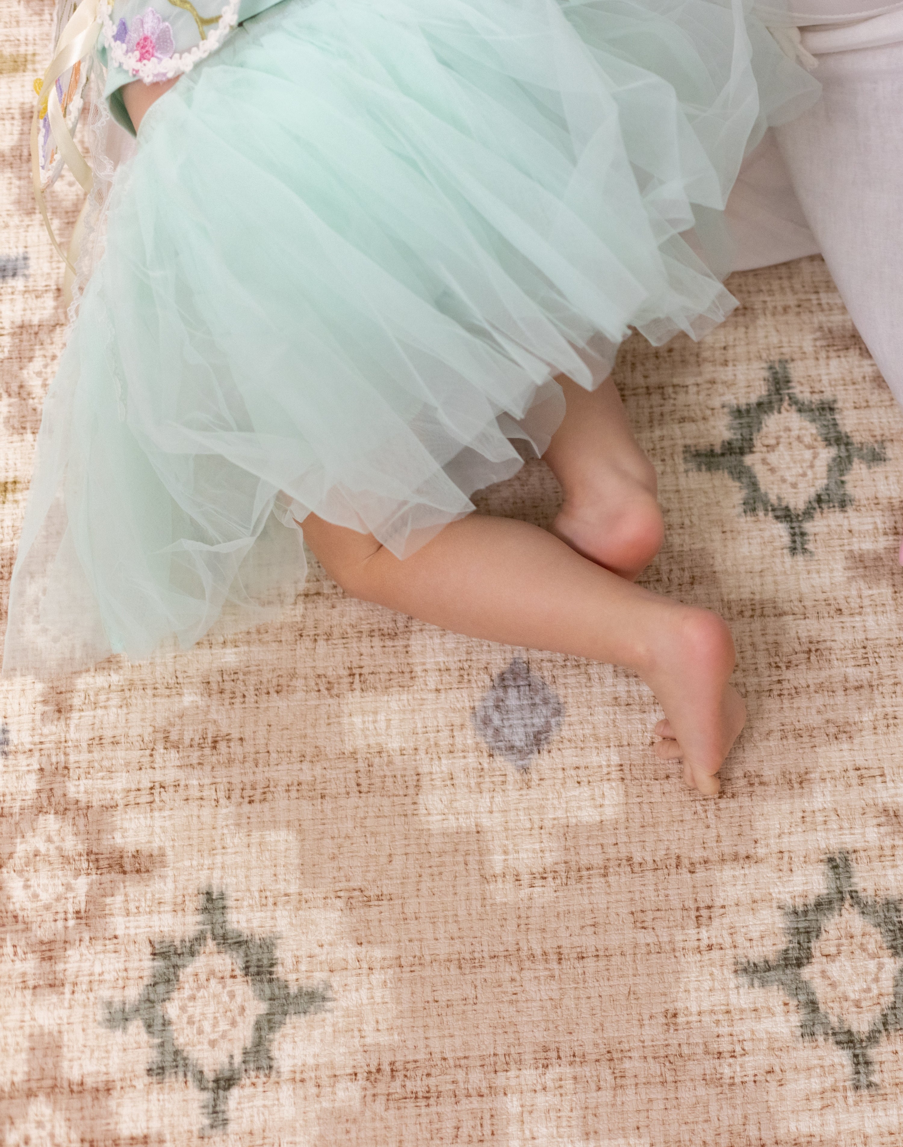 little girl crawling on baby playmat in pretty pink design The Fable