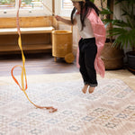 little girl jumping on totter and tumble padded play mat and having fun with soft cushioned support underfoot