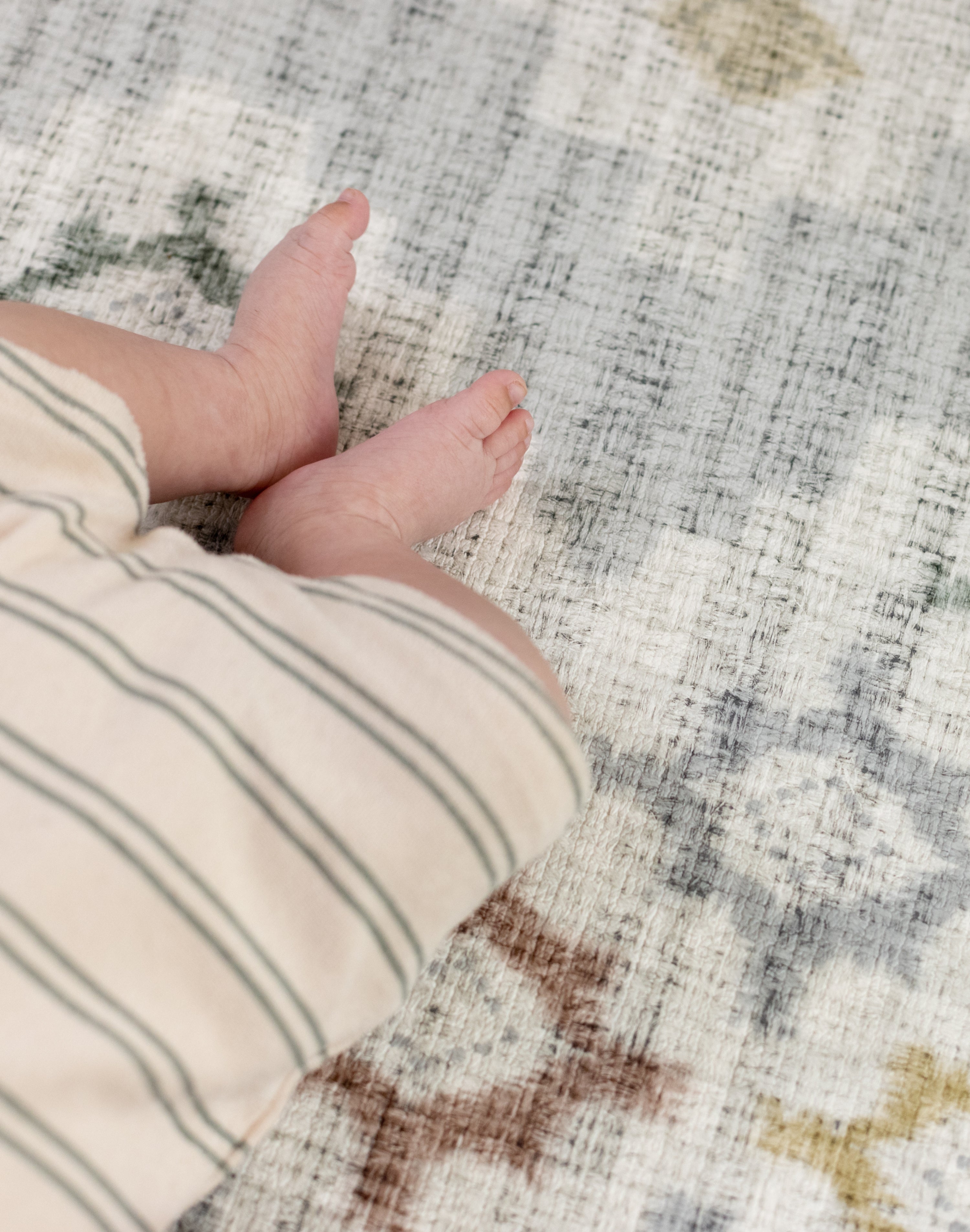 Close-up of a baby's feet on a Totter and tumble luxury one piece play mat
