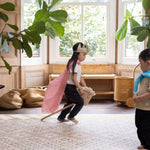 little girl playing with a hobby horse on playmat with crown magical childhood moments captured at home and on the floor with Totter + Tumble rug equivalent 