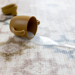 Brown cup with a white spill on a textured closed cell memory foam surface - antibacterial and easy to clean