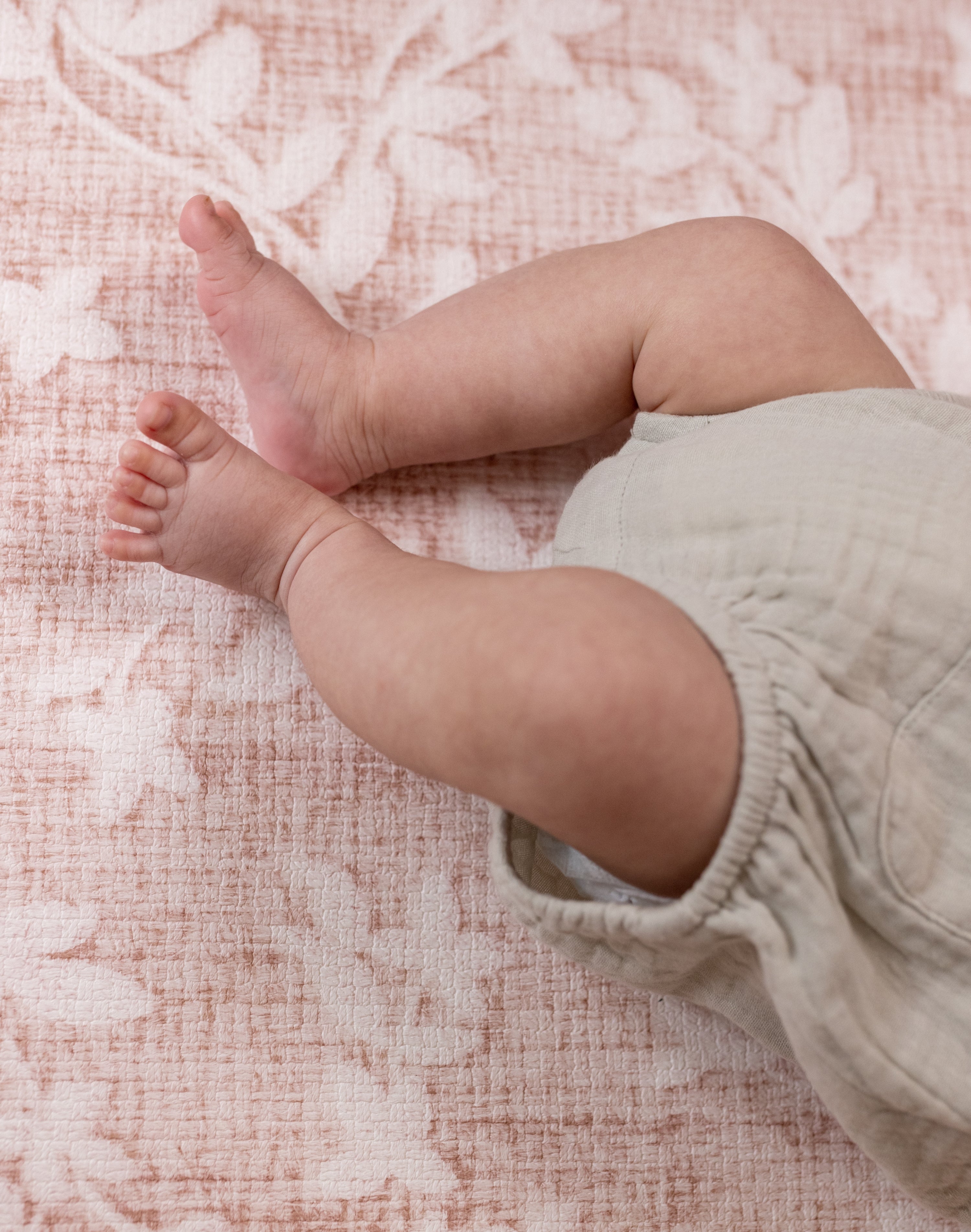 little baby legs resting on Totter and Tumble playmat neutral design for interior led home