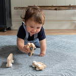 Baby boy crawls across the monochrome play mat Astronomer with a kilim design inspired by rugs 