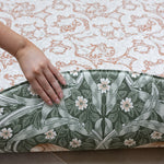 person showing the reversible design on red William Morris playmat