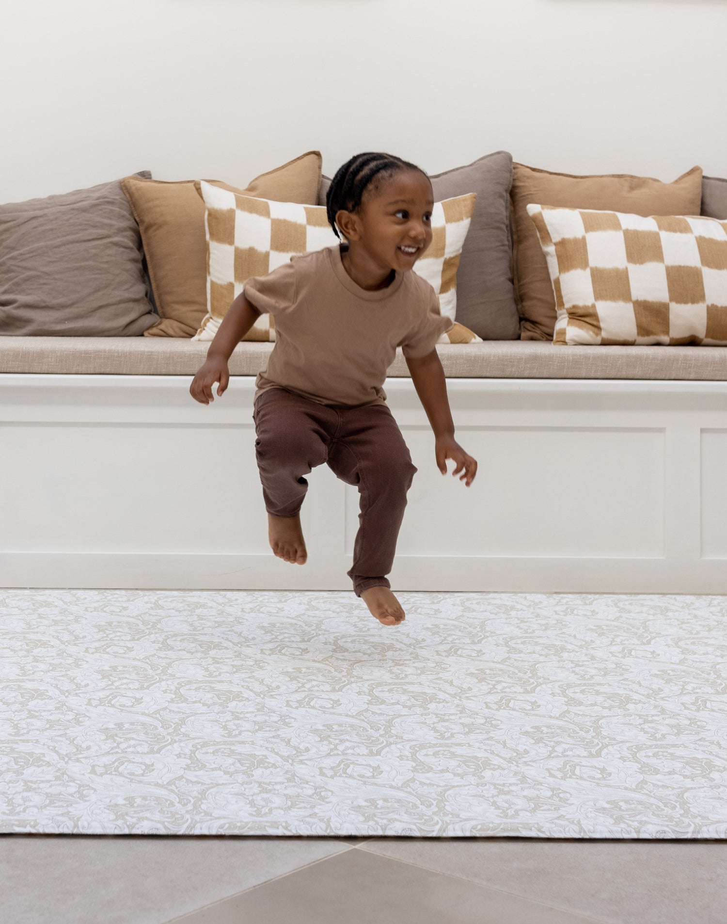 toddler jumping on cushioned play rug