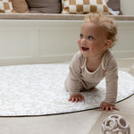 baby crawling on padded round playmat with Morris and Co designs