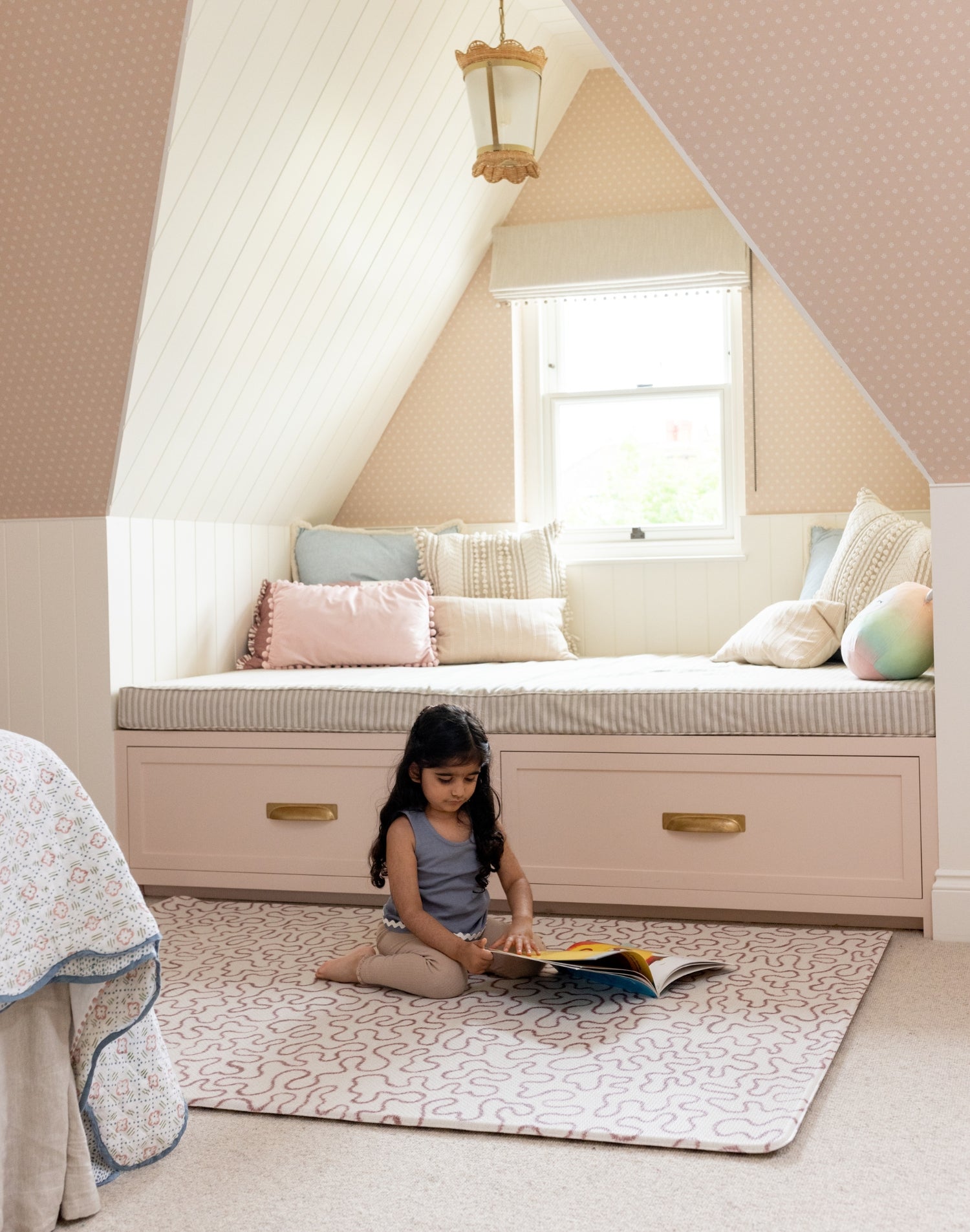 Girl reading on The Brecon, a textured, soft neutral playmat ideal for quiet time and story sessions in kids’ rooms.