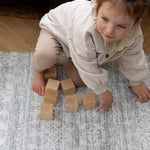 toddler plays on large padded playmat