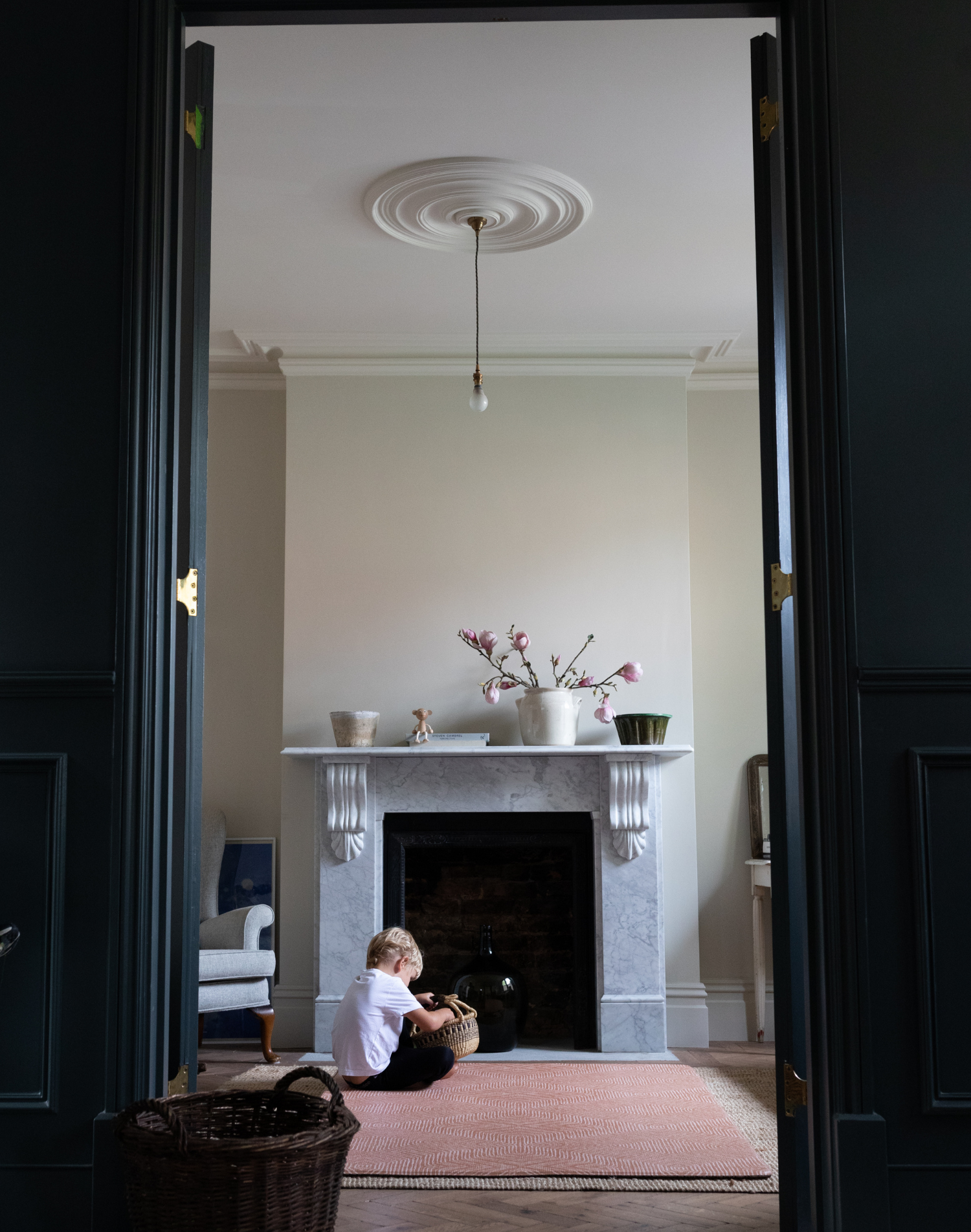 Boy plays with basket in living room sitting comfortably on durable playmat that complements modern styling 