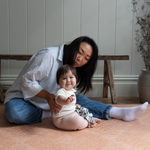 Mum and baby enjoy playing on the durable and safe playmat by totter and tumble with an earthy terracotta design