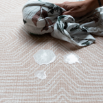 Wiping milk spillage off spill-proof playmat with clever closed cell design and modern pattern 