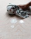 Wiping milk spillage off spill-proof playmat with clever closed cell design and modern pattern 