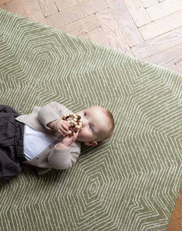 Baby plays on one piece memory foam mat with textured kilim design 