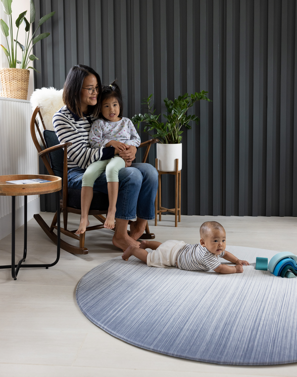 Mother and children sitting comfortably on Baby play mat safe in large round size so there is more space to play stylish blue design complements modern homes
