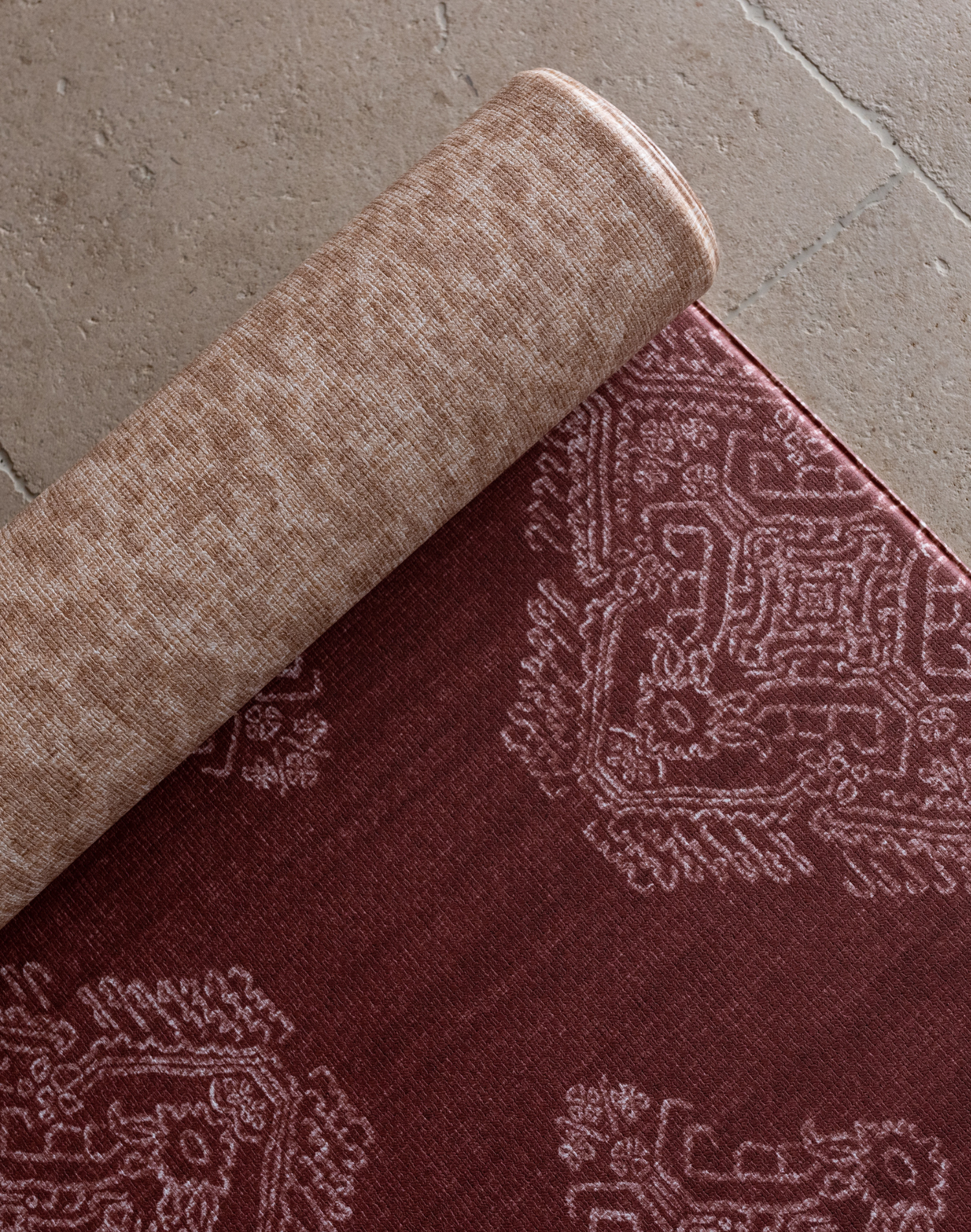 Close up of the Merah and Rusa playmats featuring a batik inspired design and a textural animal print motif