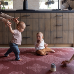 Babies play on deep red play mat The Merah and practice walking with the protection of memory foam underfoot