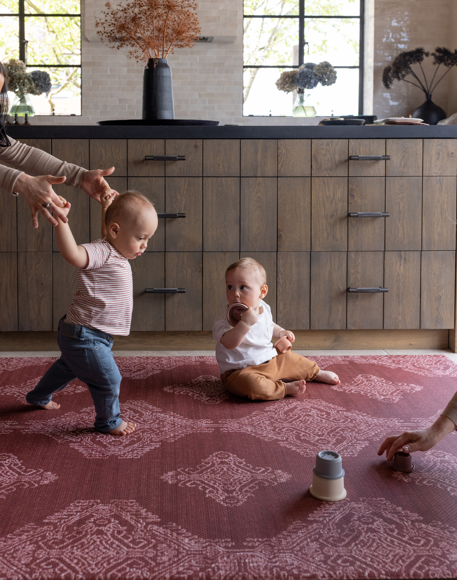 Babies play on deep red play mat The Merah and practice walking with the protection of memory foam underfoot