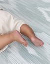Close up of baby feet on thick baby play mat made with safe materials and memory foam use from birth and enjoy for all of the developmental milestones