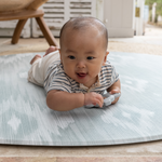 Adorable baby enjoys tummy time on thick and large baby round play mat perfect for floor time for the whole family 