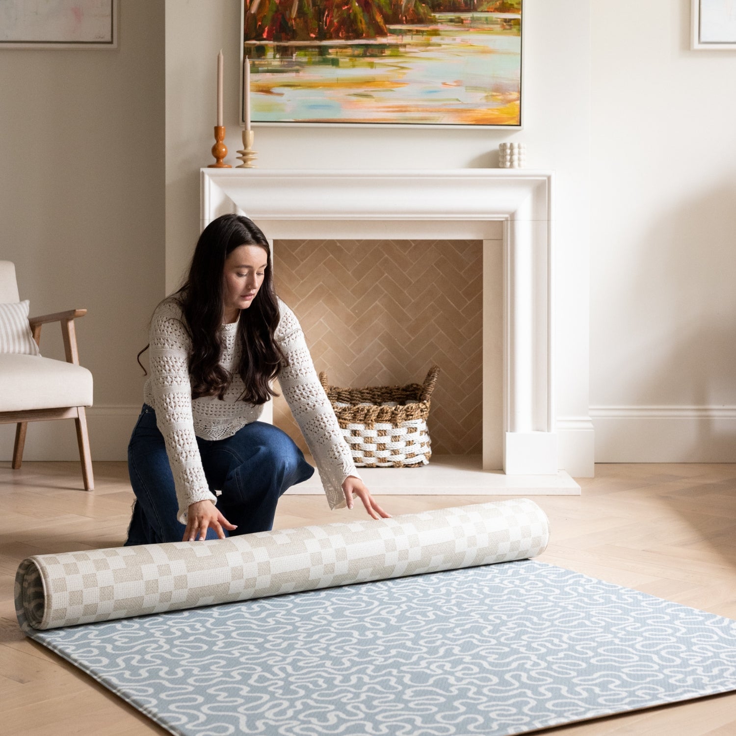 Rolling out a reversible blue and neutral baby playmat in a family room.