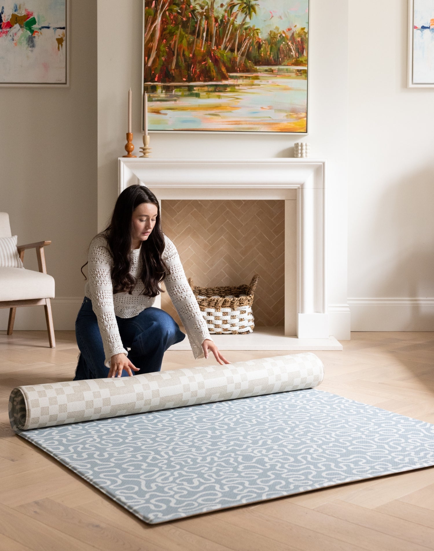 Rolling out a reversible blue and neutral baby playmat in a family room.