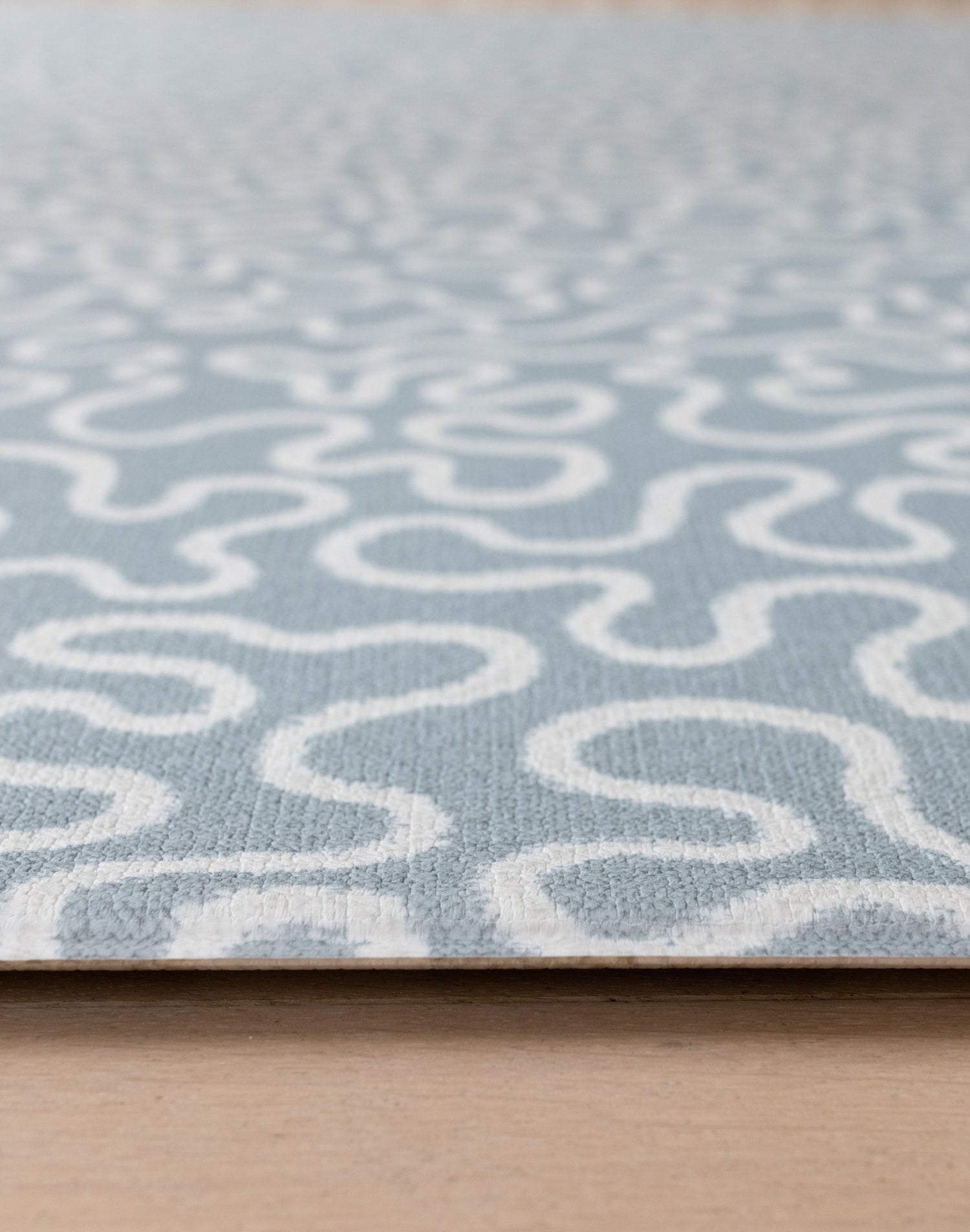 Close-up of The Pembroke, a textured baby playmat with a handwoven style in a sea foam blue, ideal as a tummy time mat.