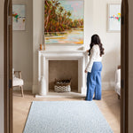 The Pembroke  handwoven style playmat styled in a modern living space, a UK-designed baby mat in soft blue.