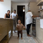 family gathering in the kitchen with baby and mother using totter and tumble play runner to cushion their feet