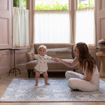 baby learning to stand on large totter and tumble padded foam playmat