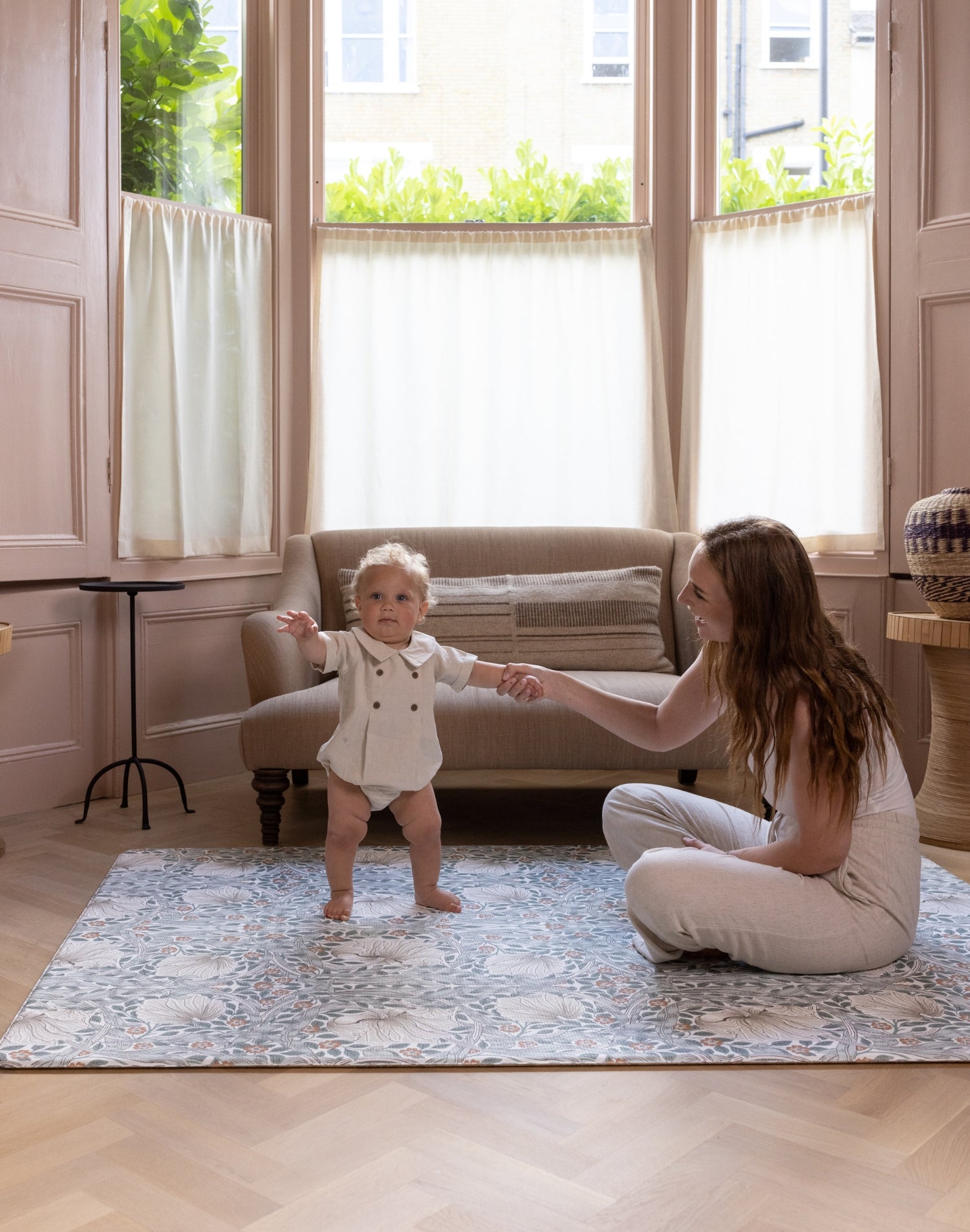 baby learning to stand on large totter and tumble padded foam playmat