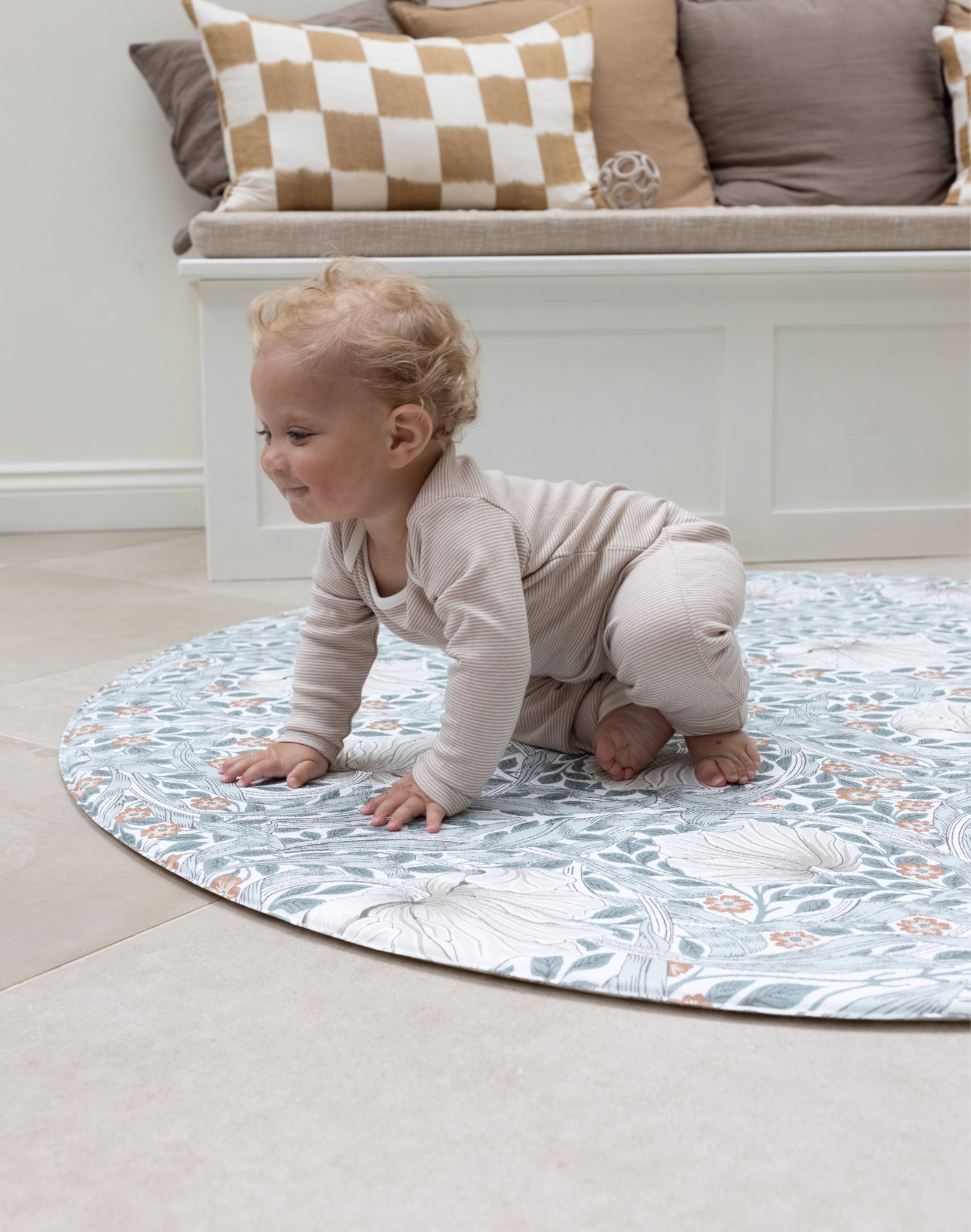 Baby crawling on round pimpernel playmat