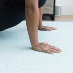 Exercising hands are supported on the thick floor mat by Totter and Tumble that provides protection from hard wood floors