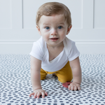 Babies hands press down on a resilient memory foam baby play mat