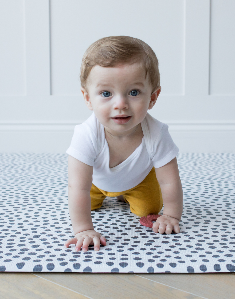 Babies hands press down on a resilient memory foam baby play mat