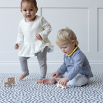 Toddlers enjoy playtime with wooden cars on a comfortable memory foam baby play mat