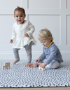 Toddlers enjoy playtime with wooden cars on a comfortable memory foam baby play mat