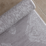 Close up of the double sided grey play mat the sepi with a intricate hand drawn design that feels like a heritage rug on the reverse the animal print design has a gentle textural quality unroll anywhere in the home with thick memory foam that provides protection on hard flooring during floor time activities